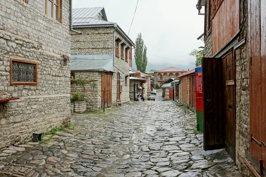 A carved wooden door on a cobbled street in the coppersmith town of Lahic.
